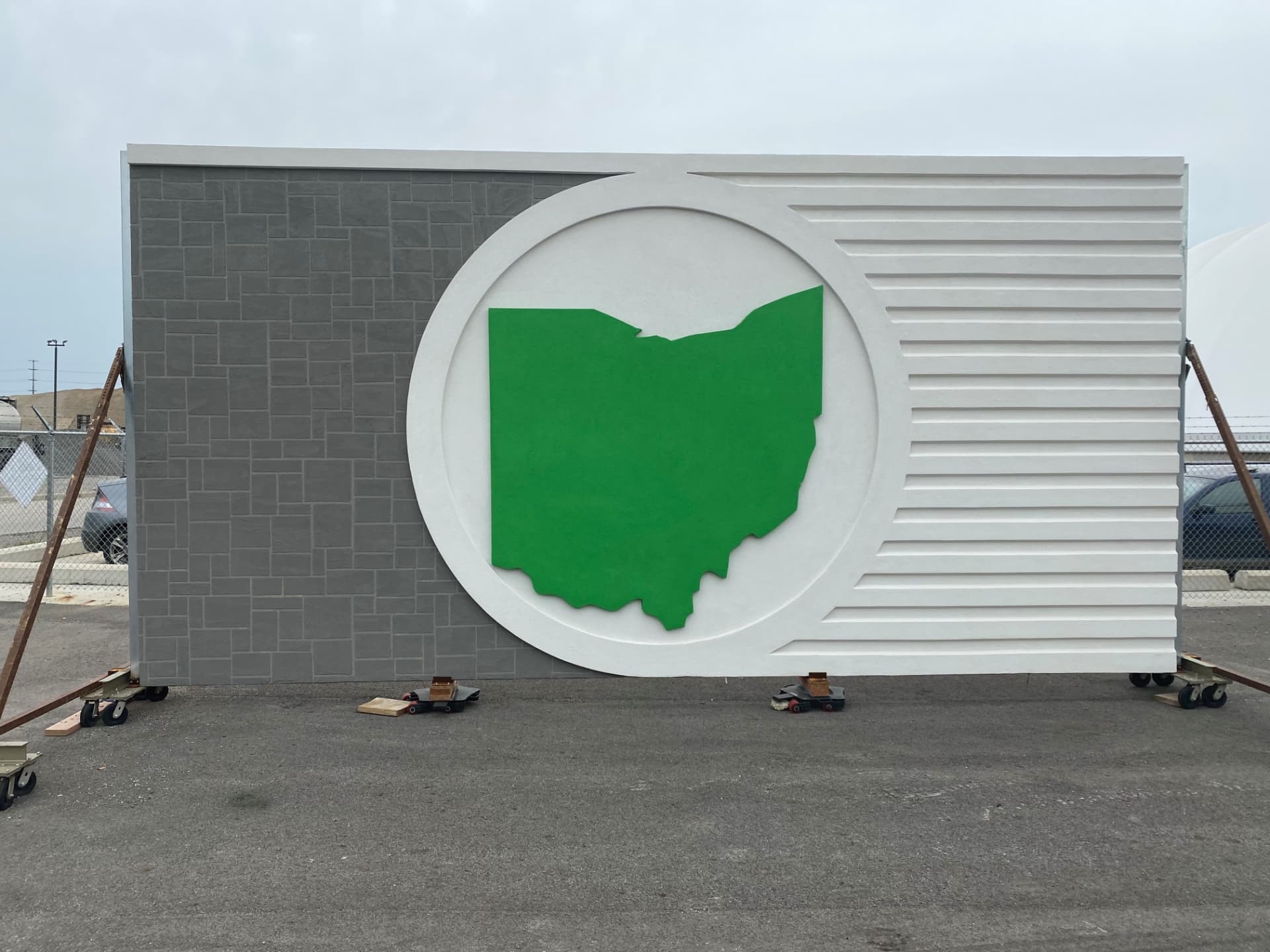 Infinity Wall panel with custom finishes: a gray tile-pattern section, a white circle with the green Ohio state logo, and a white fluted section