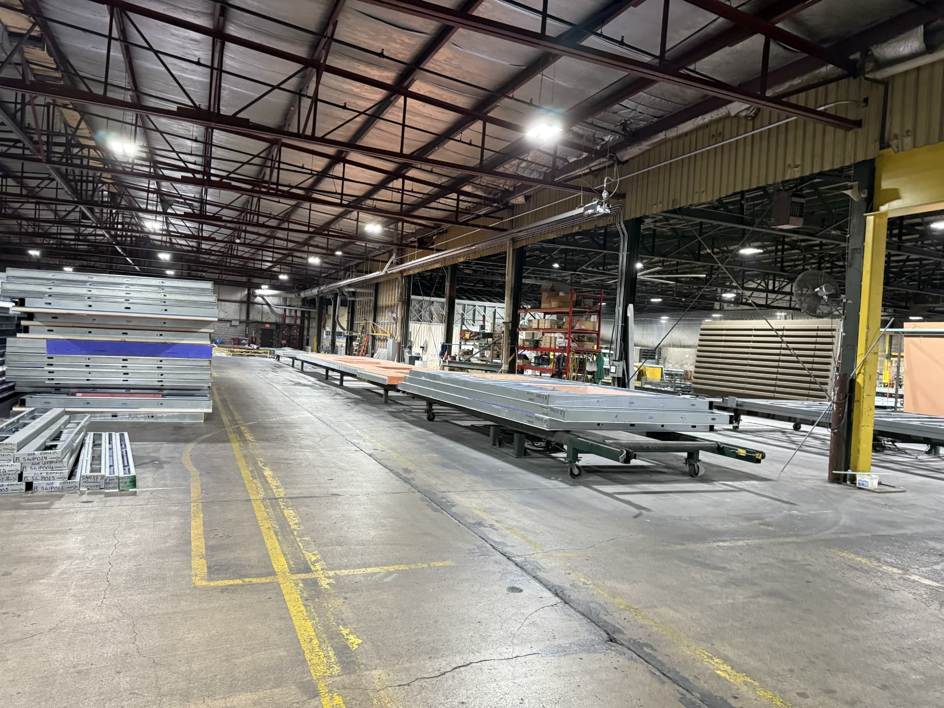 NWB fabrication facility interior with wall panels staged on carts