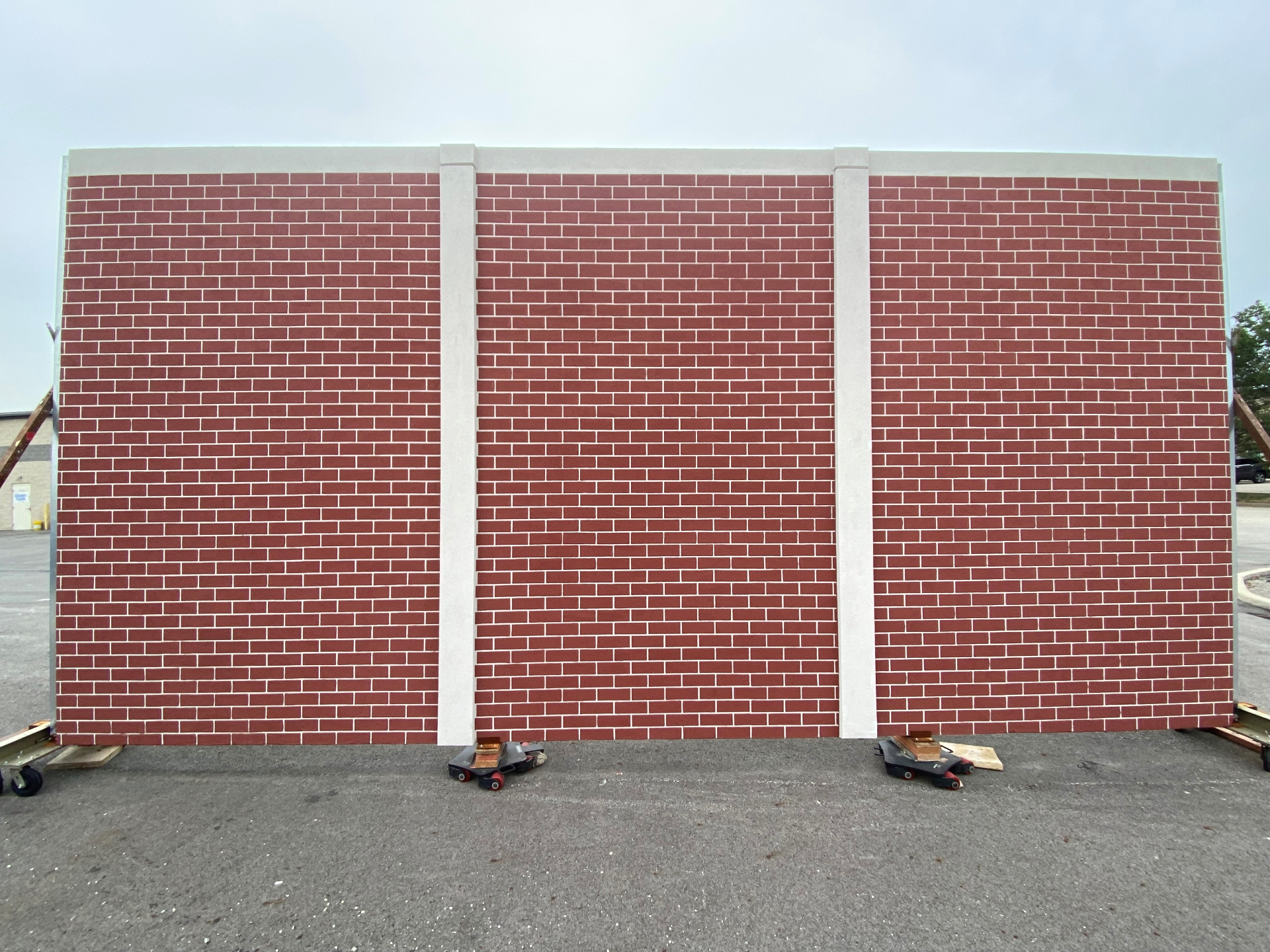 Infinity Wall panel finished as a red brick wall, built to read as separate 12-by-8-foot wall sections